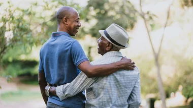 Father and son smiling outside
