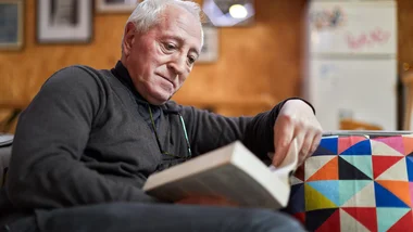 Man reading a book while sitting on a couch