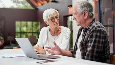 A man and a woman are sitting at a table having a conversation.