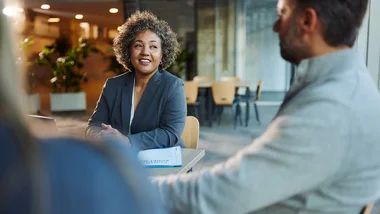 Group of people sitting at a conference table having a conversation.